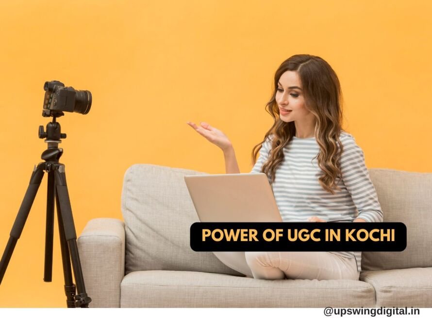 A woman sitting on a couch with a laptop, gesturing towards a camera on a tripod. The background is orange, and the text overlay reads "Power of UGC in Kochi." The image is credited to @upswingdigital.in.