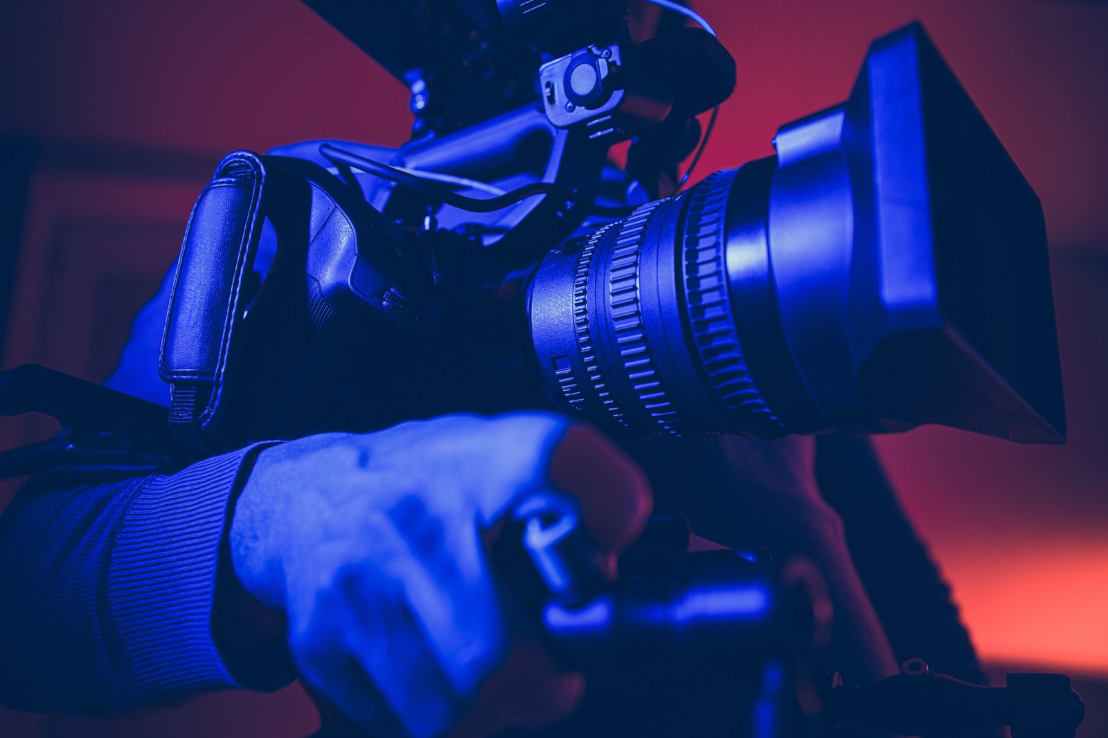 A professional cameraman filming a crowd at night using high-end video equipment, showcasing the behind-the-scenes setup of a professional video shoot in a public space.
